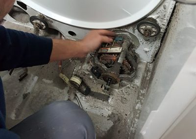 Réparateur qui change des pièces de la sècheuse - Atelier Anjou Réparation d'électroménagers à Anjou